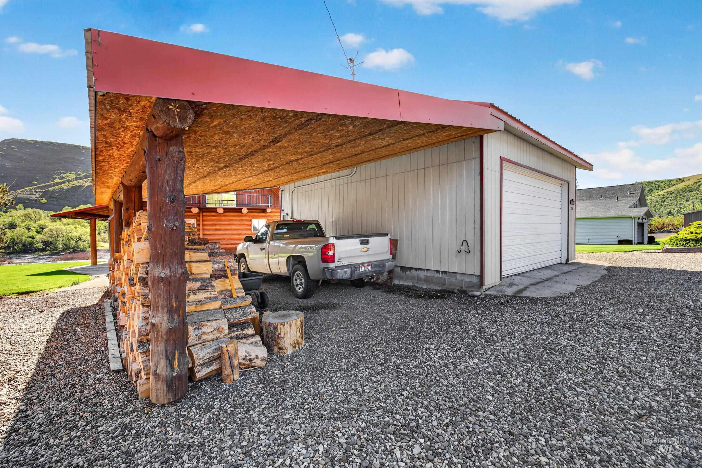 215 Doumecq Road White Bird, ID 83554 - Photo 40 of 50 Carport with a red metal roof and log columns
