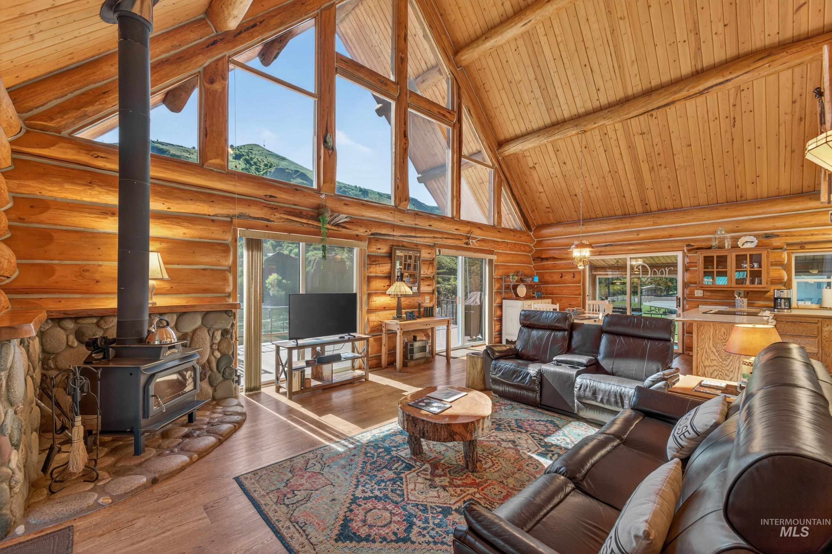 215 Doumecq Road White Bird, ID 83554 - Photo 7 of 50 Vaulted wood-paneled ceiling with exposed beams, wood-finish flooring, and large picture windows