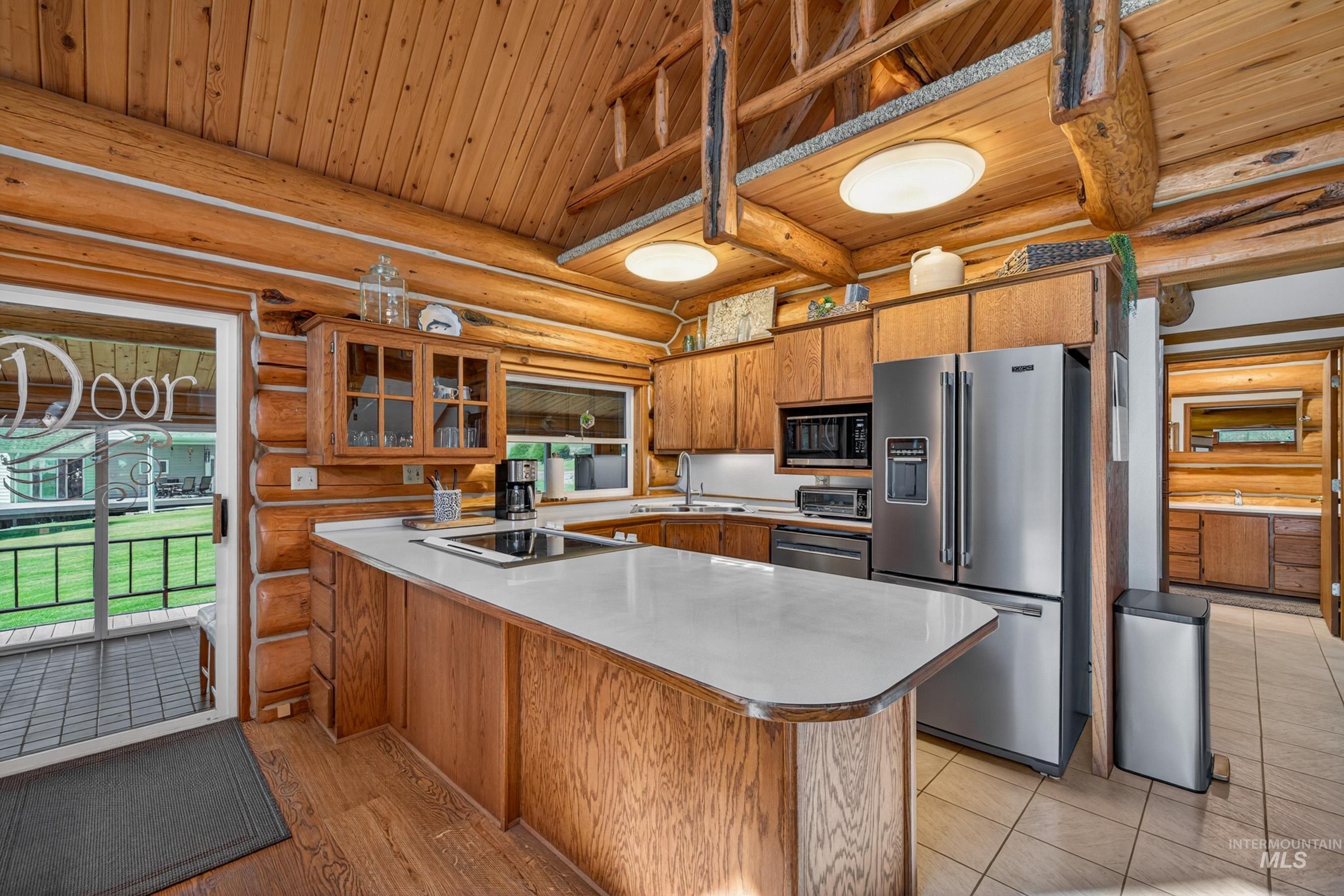 215 Doumecq Road White Bird, ID 83554 - Photo 10 of 50 Kitchen featuring a large central island with a white countertop, wood cabinetry, stainless steel appliances, and wood-finish flooring