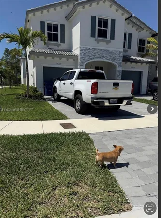 a white house covered with tall trees