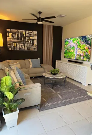 a living room with furniture and a potted plant