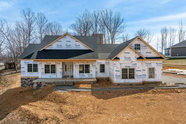 a front view of a house with a yard covered in snow
