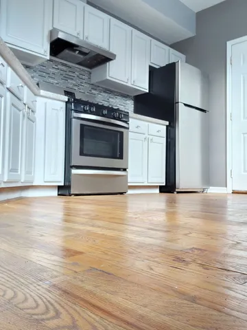 a kitchen with stainless steel appliances a stove a refrigerator and a microwave