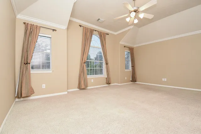 an empty room with windows and fan