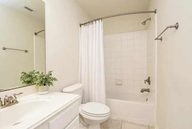 an empty room with a chandelier fan and windows