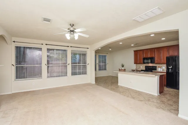 a view of an empty room with a kitchen and a sink