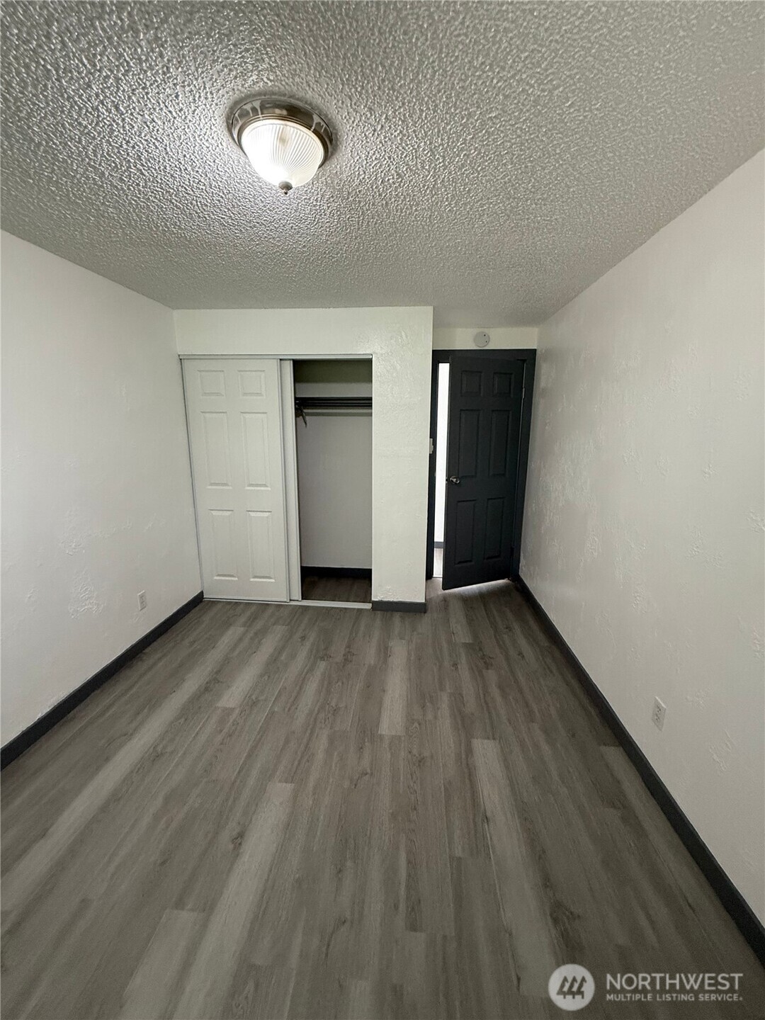 1007 MacFarlane Street Aberdeen, WA 98520 - Photo 11 of 23 an empty room with wooden floor and windows