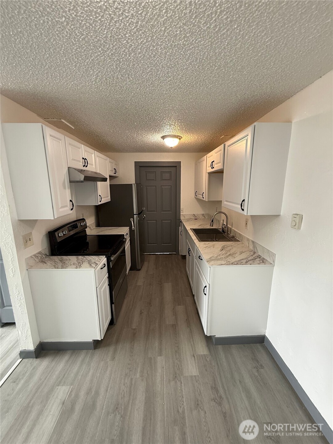 1007 MacFarlane Street Aberdeen, WA 98520 - Photo 12 of 23 a kitchen with sink a stove and refrigerator