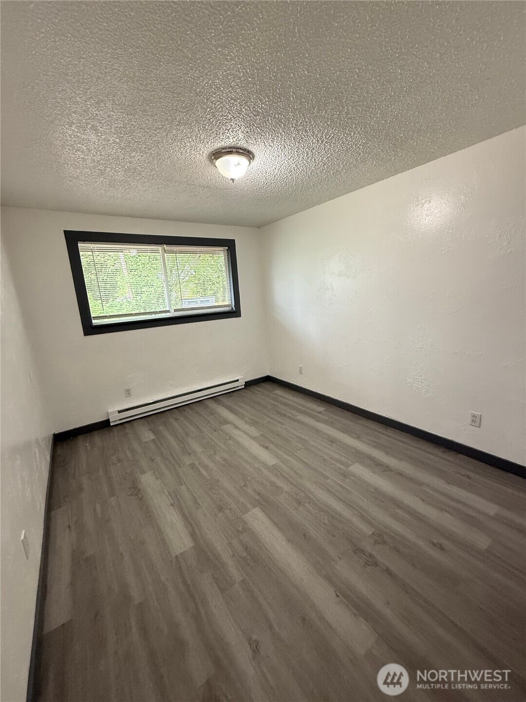 1007 MacFarlane Street Aberdeen, WA 98520 - Photo 15 of 23 an empty room with wooden floor and windows