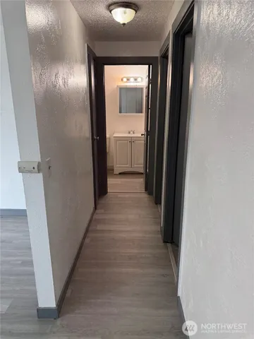 a view of a hallway with wooden floor