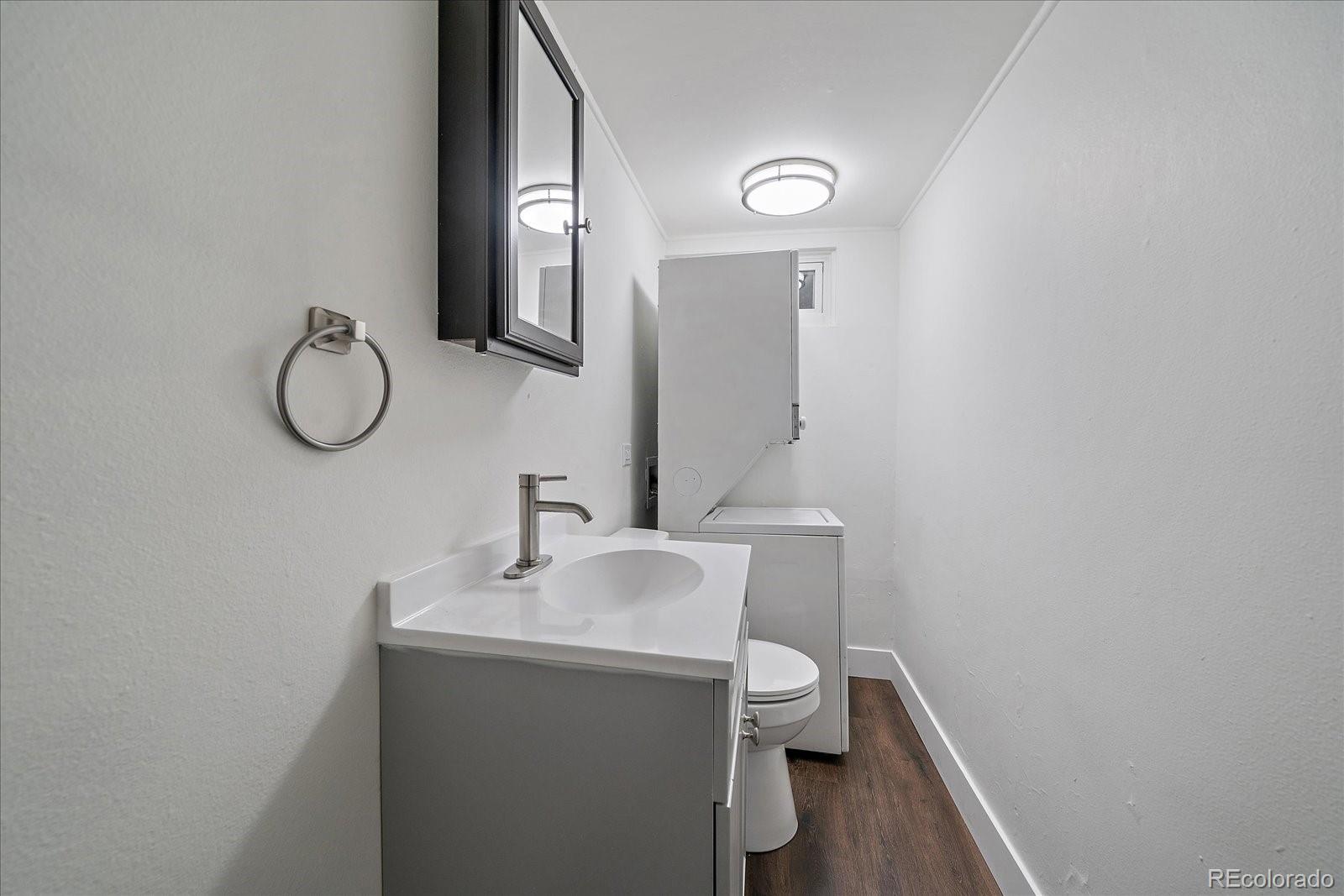 3738 Miller Court Wheat Ridge, CO 80033 - Photo 17 of 20 a bathroom with a toilet a sink and mirror