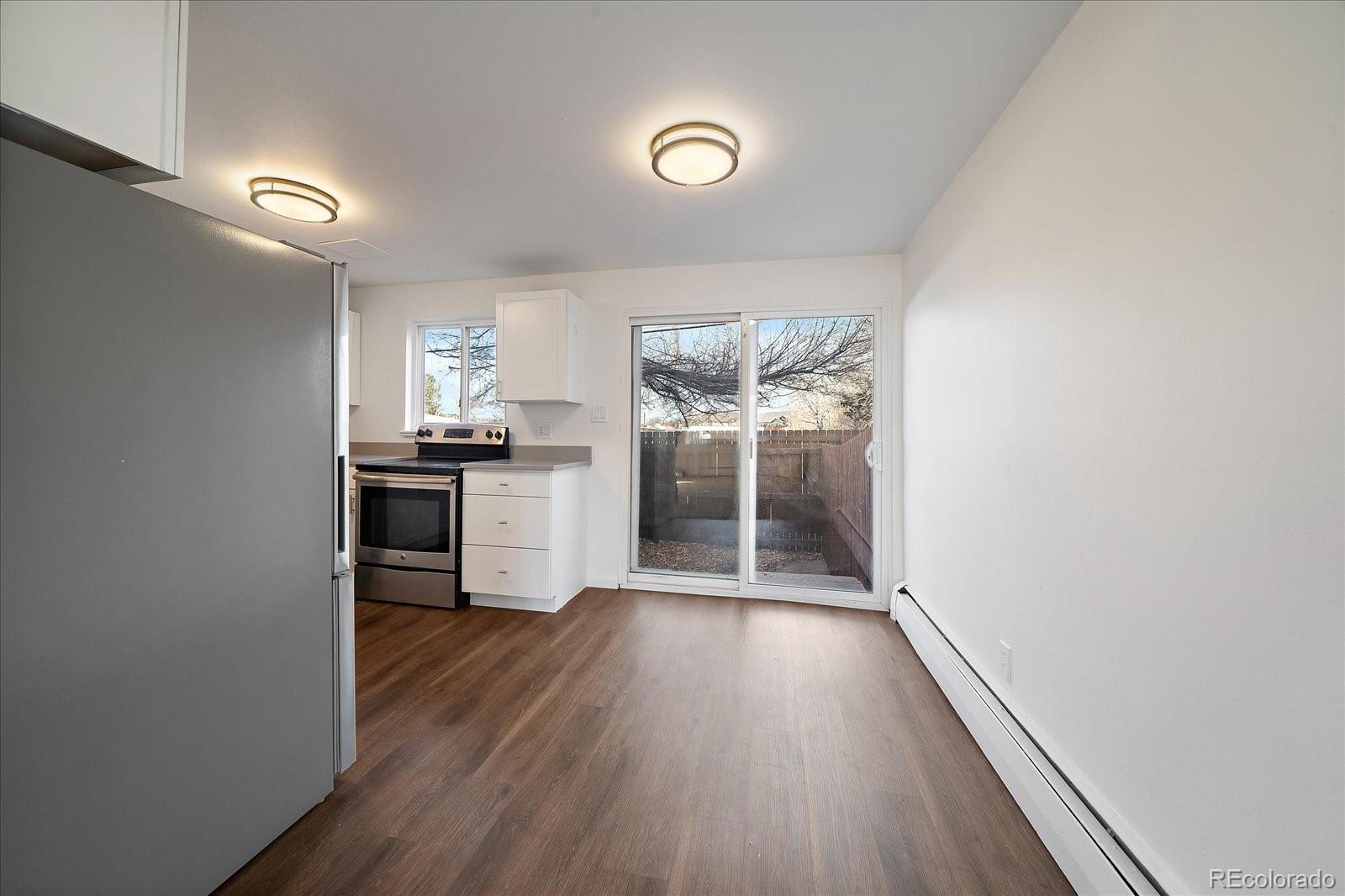 3738 Miller Court Wheat Ridge, CO 80033 - Photo 6 of 20 wooden floor in an empty room and a kitchen