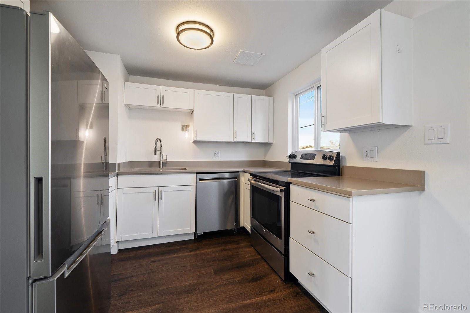 3738 Miller Court Wheat Ridge, CO 80033 - Photo 7 of 20 a kitchen with granite countertop white cabinets and white appliances