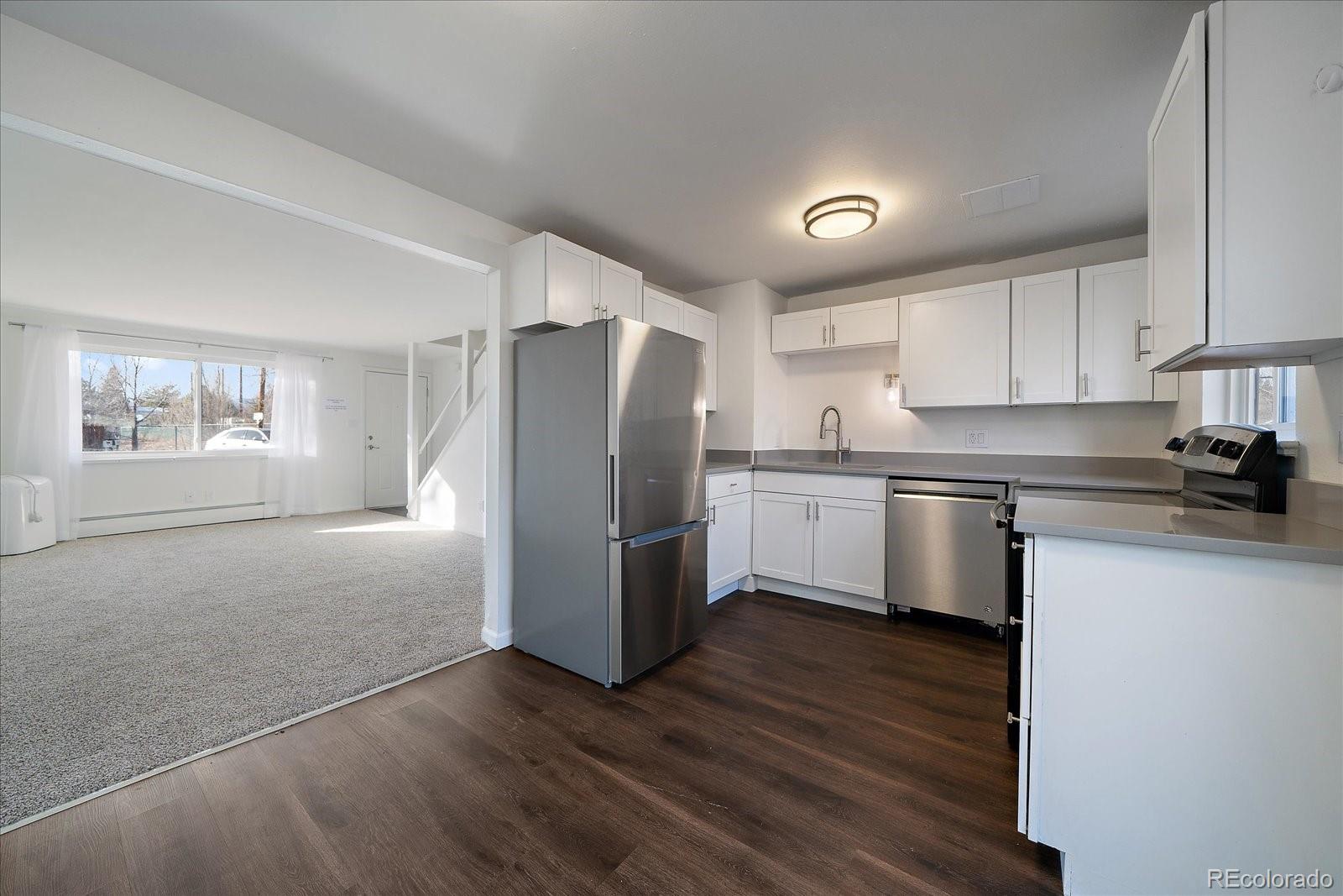 3738 Miller Court Wheat Ridge, CO 80033 - Photo 9 of 20 a kitchen with a refrigerator a sink and cabinets