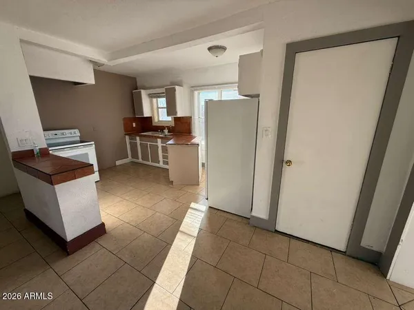 a view of kitchen with furniture and refrigerator