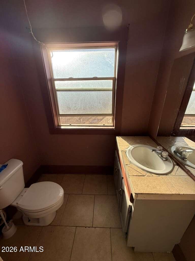 1165 East 10th Street, Unit 3 Douglas, AZ 85607 - Photo 10 of 22 a bathroom with a toilet sink and mirror