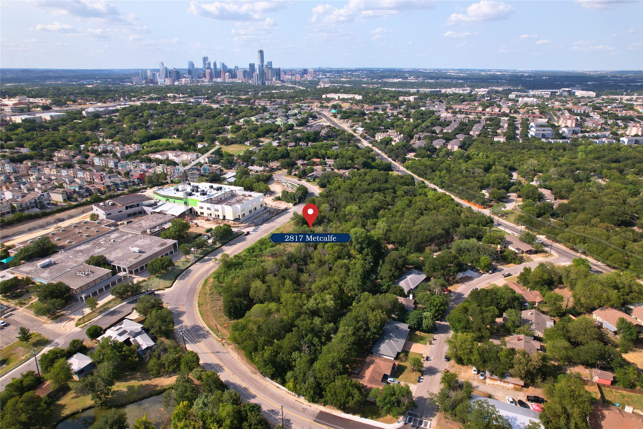 an aerial view of residential houses with outdoor space and trees