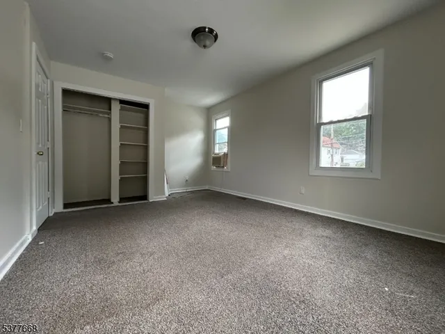 an empty room with windows and closet