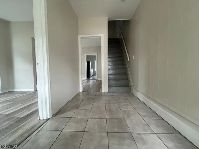 a view of a hallway with entryway and stairs