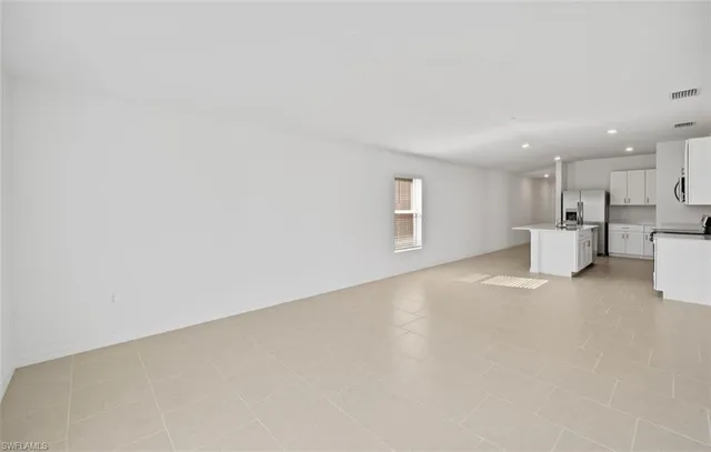 a view of a big room with windows and a refrigerator