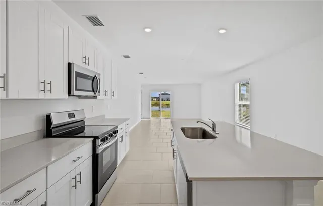 a kitchen with a sink a stove and cabinets