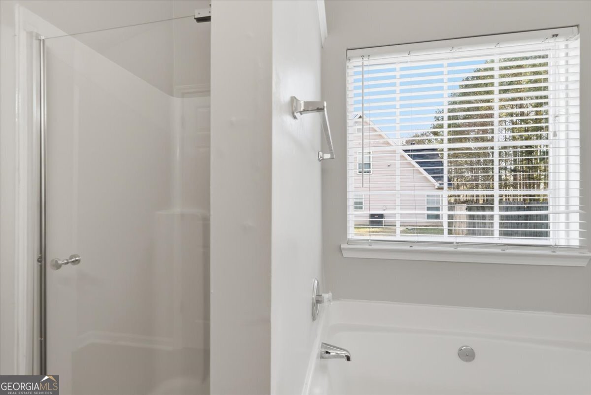 946 Damson Trail Hampton, GA 30228 - Photo 25 of 37 a bathroom with a bathtub and a shower