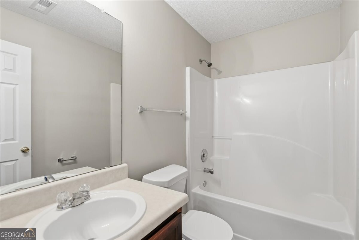 946 Damson Trail Hampton, GA 30228 - Photo 28 of 37 a bathroom with a sink toilet and shower