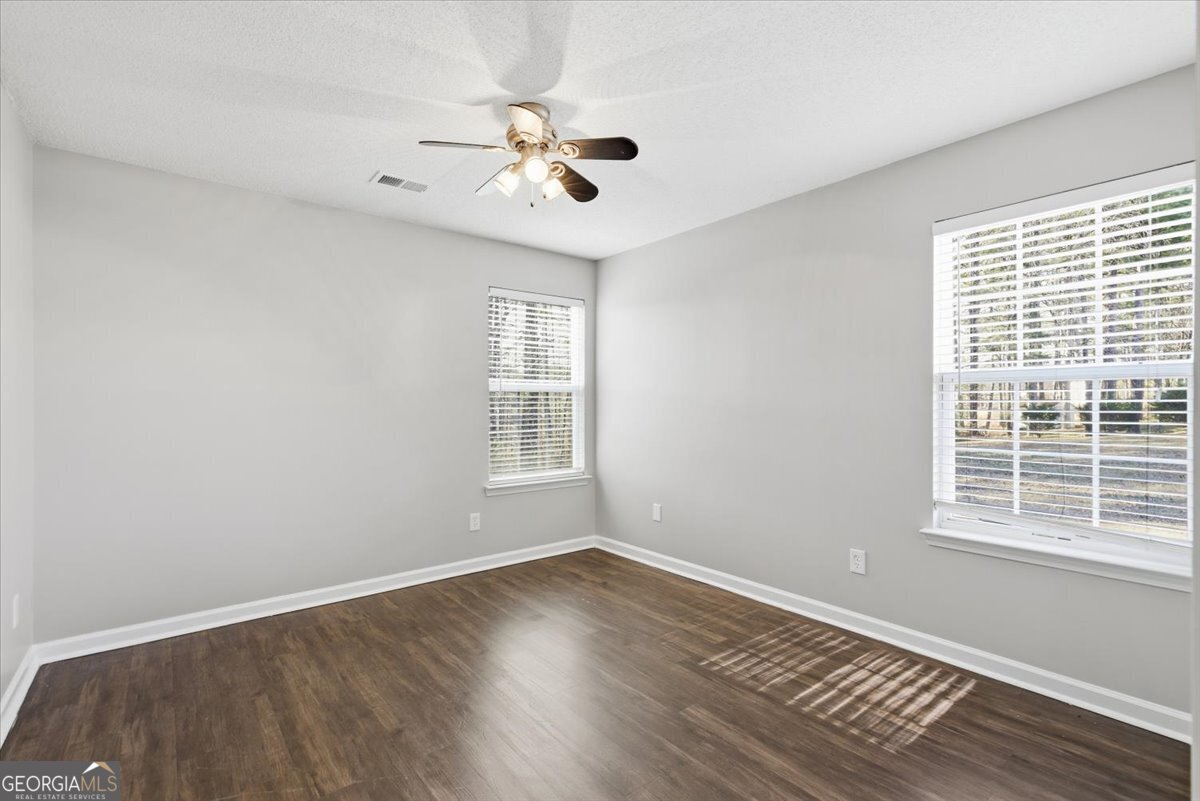 946 Damson Trail Hampton, GA 30228 - Photo 29 of 37 a view of an empty room with wooden floor and a window