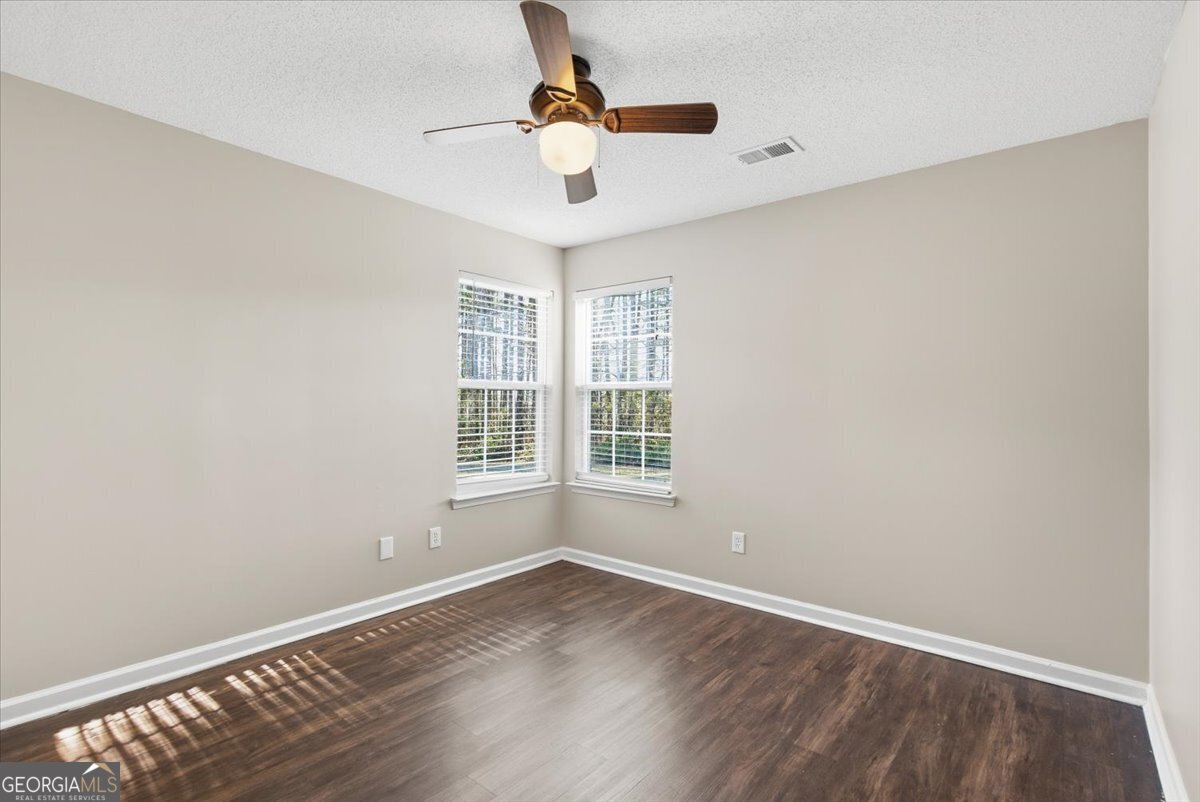 946 Damson Trail Hampton, GA 30228 - Photo 30 of 37 an empty room with wooden floor fan and windows