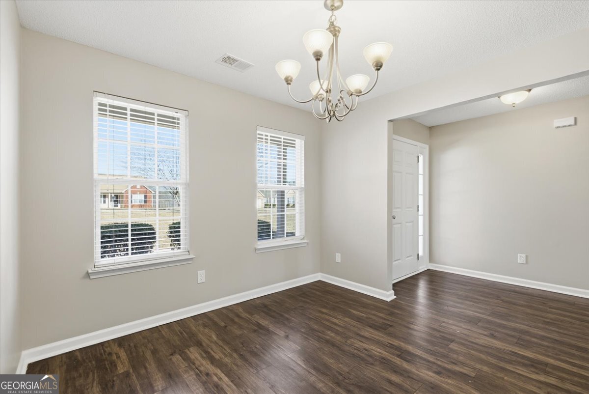 946 Damson Trail Hampton, GA 30228 - Photo 7 of 37 a view of an empty room with wooden floor and a window