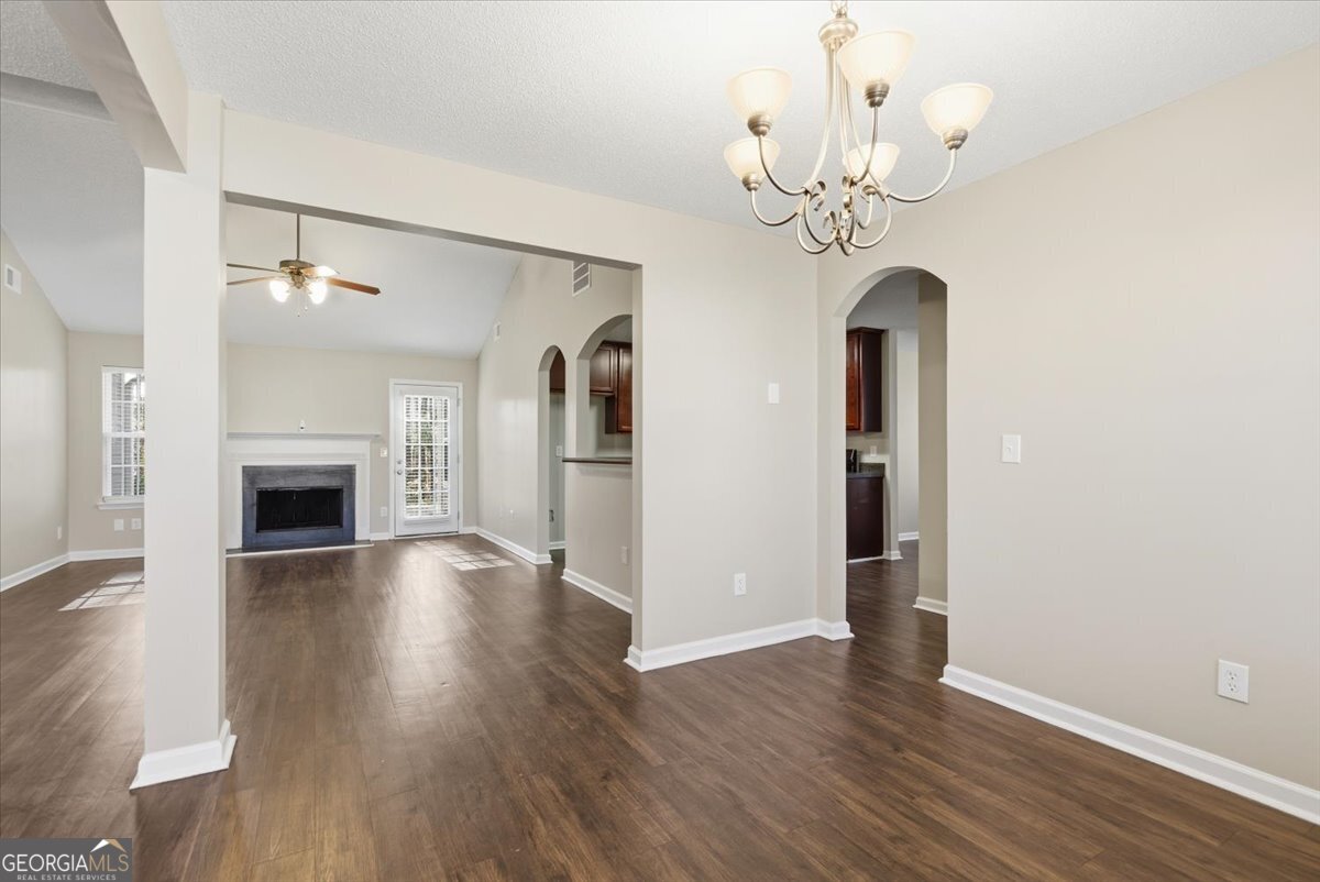 946 Damson Trail Hampton, GA 30228 - Photo 8 of 37 a view of a hallway with wooden floor and a chandelier