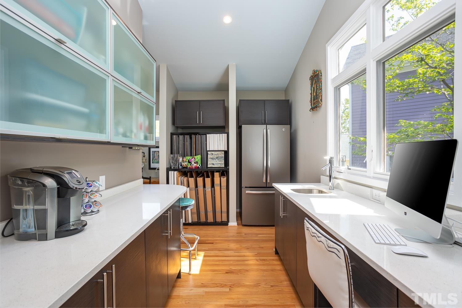 601 Leonidas Court Raleigh, NC 27604 - Photo 6 of 53 a kitchen with stainless steel appliances a sink dishwasher a refrigerator a stove and a dining table with wooden floor