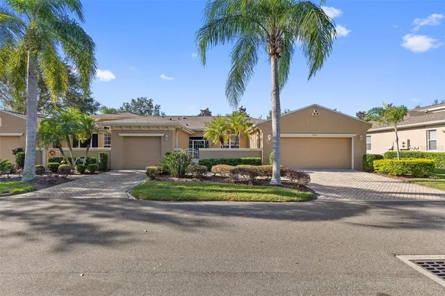 a view of a house with a yard and palm trees