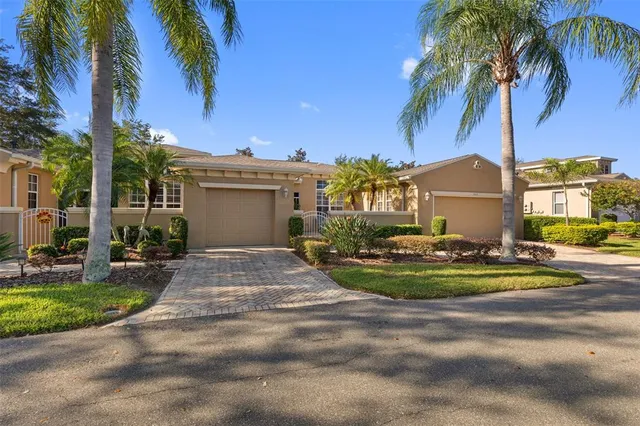 a front view of a house with a yard and palm trees
