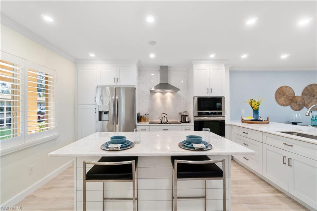 5975 Bloomfield Circle, Unit C108 Naples, FL 34112 - Photo 2 of 50 Breakfast island with white marble and shiplap accent offers additional dining space