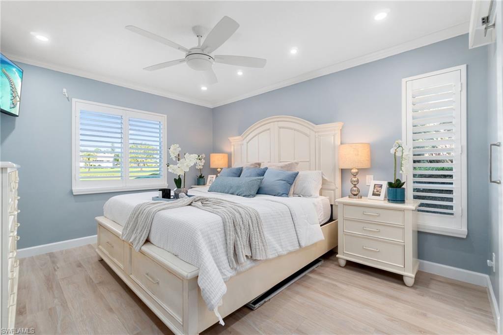 5975 Bloomfield Circle, Unit C108 Naples, FL 34112 - Photo 24 of 50 Spacious primary suite features an abundance of natural light with golf course and lake views, while privacy is offered by plantation shutters. Fresh paint, light, wood-like luxury vinyl flooring and crown molding enhance the spaciousness