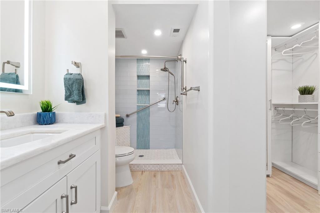 5975 Bloomfield Circle, Unit C108 Naples, FL 34112 - Photo 27 of 50 Stunning marble countertops, white shaker cabinets, shower fog-free mirrors, custom glass tile, walk-in shower, and custom walk-in closet