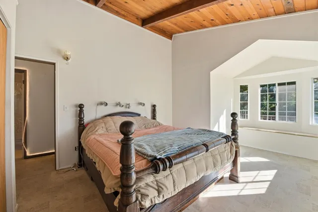 a bedroom with a bed and a large window