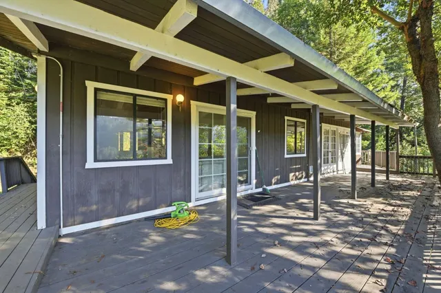 a view of a patio with table and chairs and wooden fence