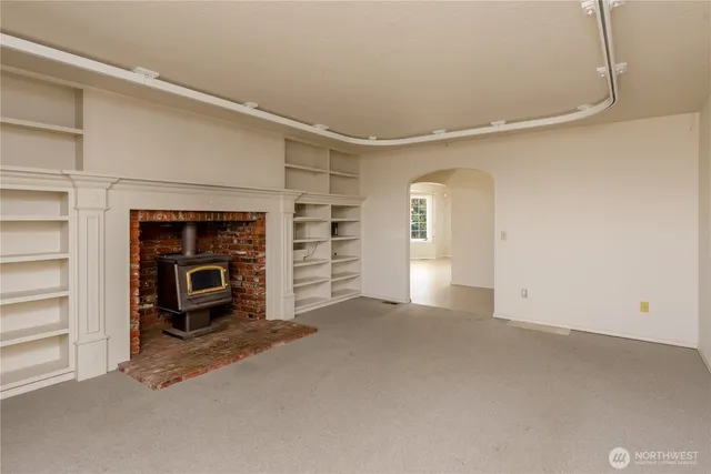 a view of an empty room with a fireplace and a window