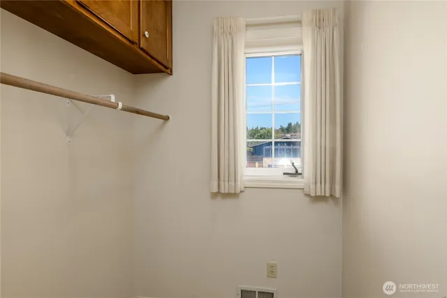 a bedroom with a bed a window and a flat screen tv