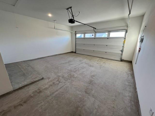 1407 Cartona Road Fate, TX 75087 - Photo 16 of 21 Spacious garage featuring a concrete floor, white painted walls, and an overhead garage door with integrated windows