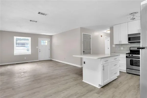 a kitchen with stainless steel appliances white cabinets and a refrigerator