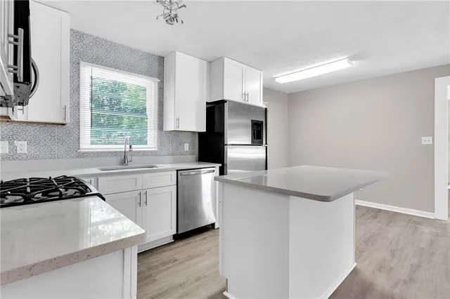 a kitchen with stainless steel appliances granite countertop a sink stove and refrigerator