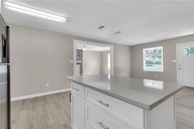 a kitchen with stainless steel appliances granite countertop a sink and a white cabinets