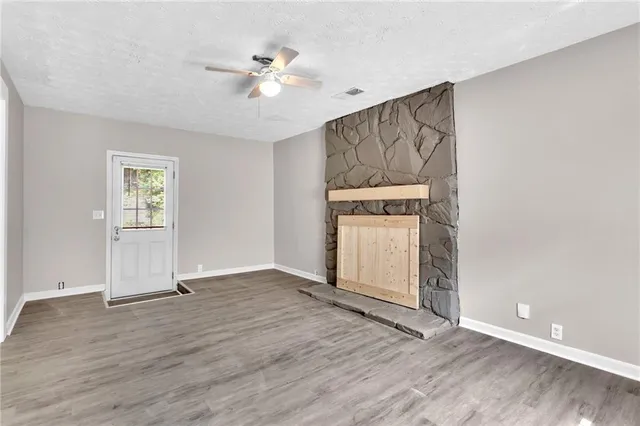an empty room with windows and ceiling fan
