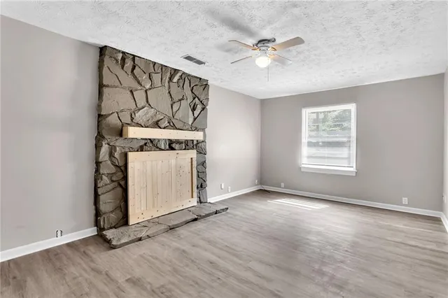 an empty room with windows and fan