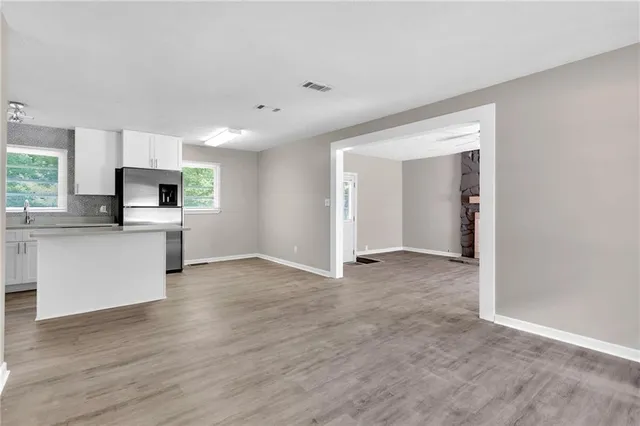 a view of a kitchen with a sink stove cabinets and empty room