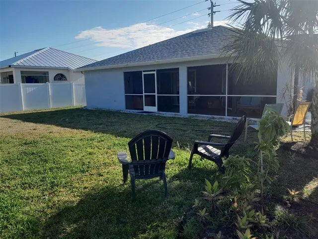 a view of backyard with table and chairs and wooden fence
