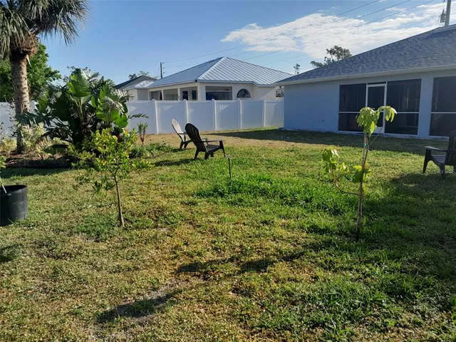 a front view of a house with a yard and potted plants